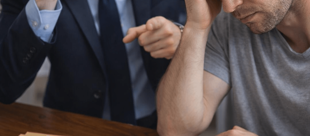 Debt collector angrily calling on phone while a worried consumer reviews legal debt documents at a desk, illustrating debt collection pressure and potential FDCPA violations.